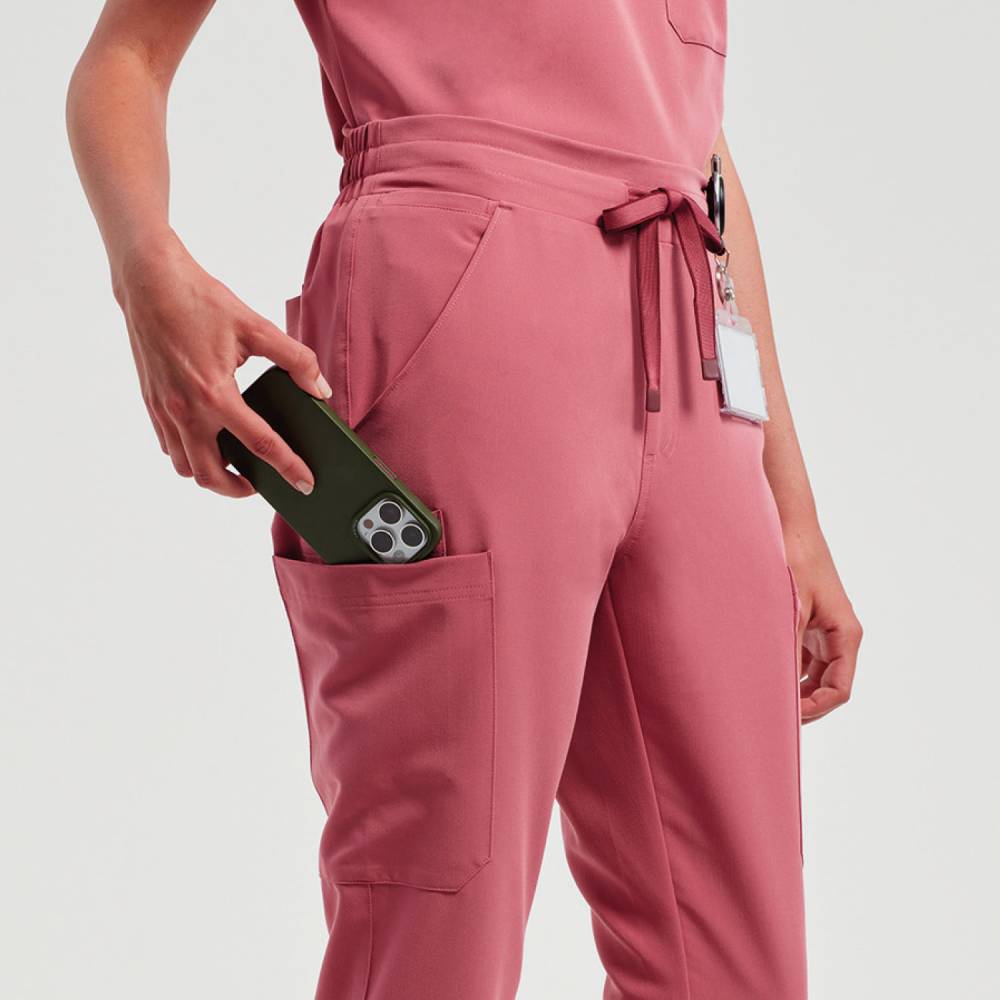 A close up of a woman wearing Onna by Premier scrub trousers in calm pink
